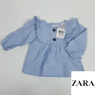 Blouse bleu clair avec bouton nacré